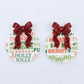 One pair of Christmas Text UV printed bauble dangle blanks with included red glitter bows laying flat.