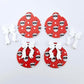 Two pairs of Jolly Cool UV printed bauble dangle blanks with included white bows laying flat
