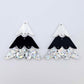 One pair of 40mm three piece Christmas Tree dangle earring blanks in holographic silver glitter, black and white marble acrylic laying flat on a white background