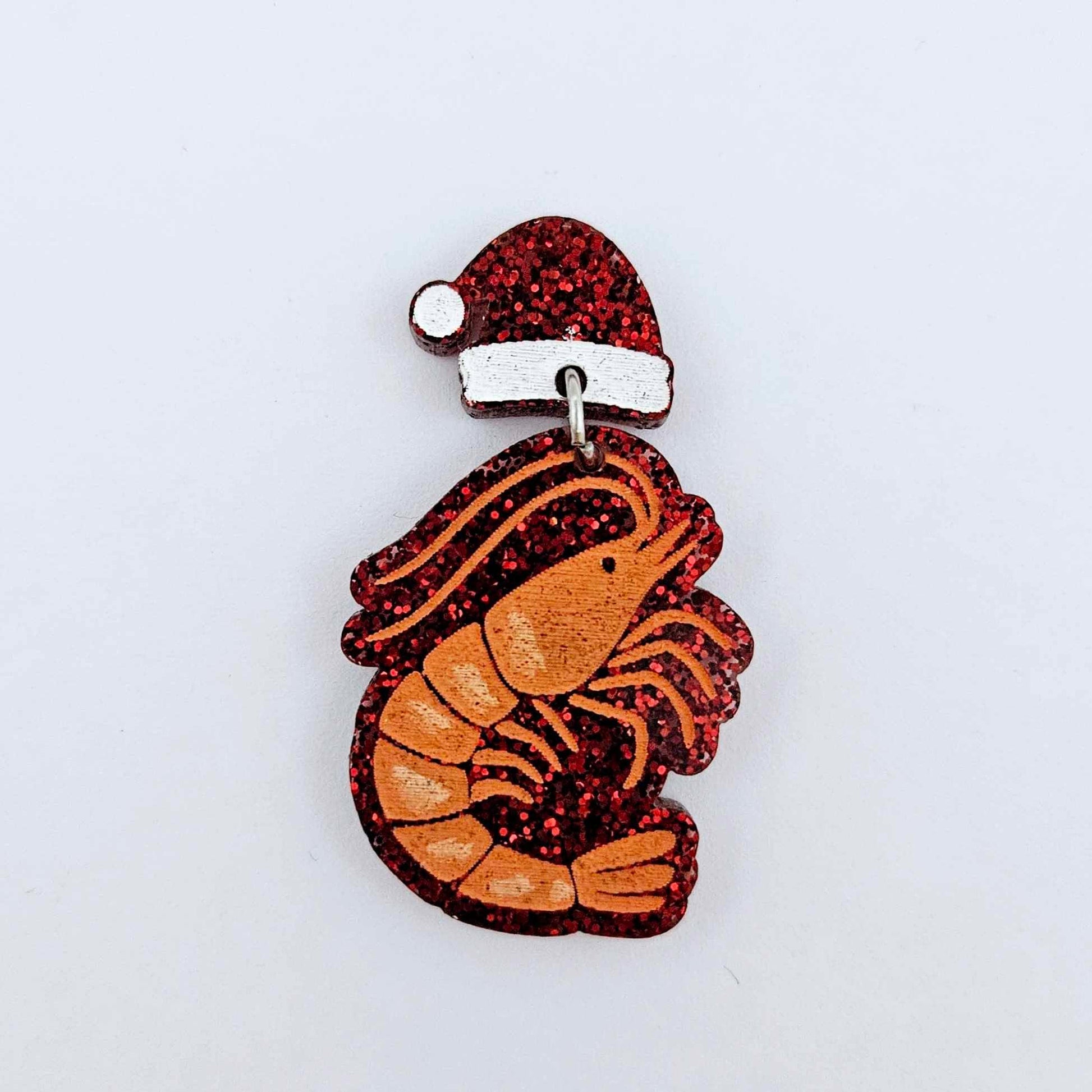 One red glitter Santa hat topper attached to a Christmas prawn dangle, shown as a finished festive earring design