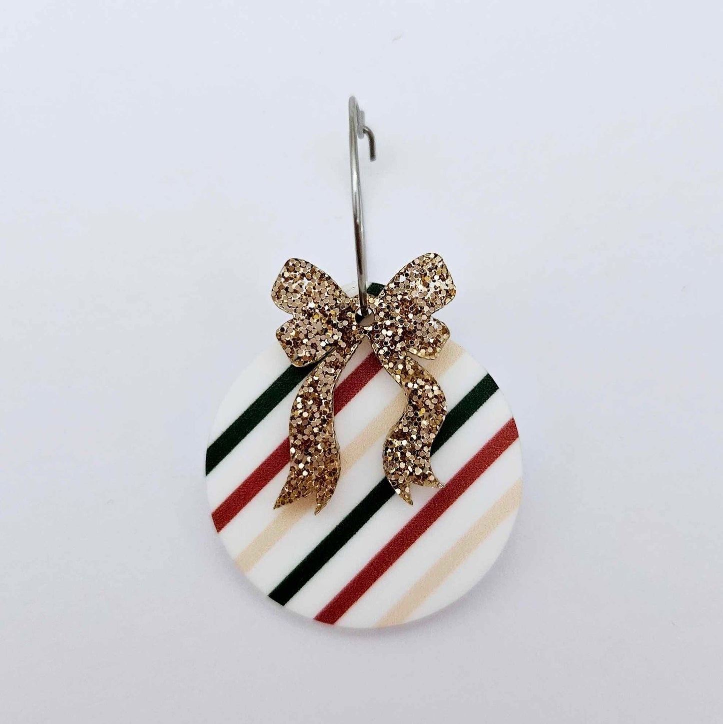 One rose gold glitter acrylic bow shown paired with a UV printed bauble on a 20mm hoop