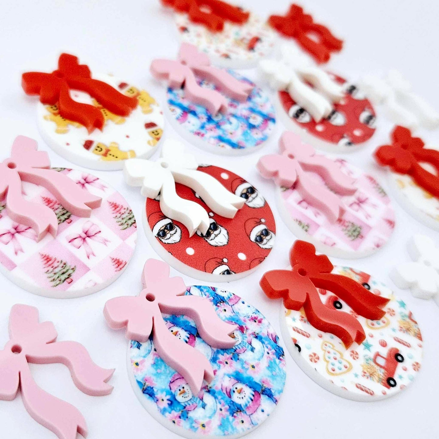 A selection of the five Fun Christmas UV printed bauble dangle earring blank designs with their coordinating bows laying flat.