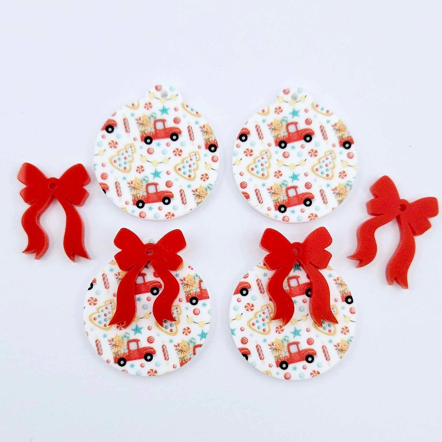 Two pairs of Vintage Truck UV printed bauble dangle blanks with included solid red bows laying flat