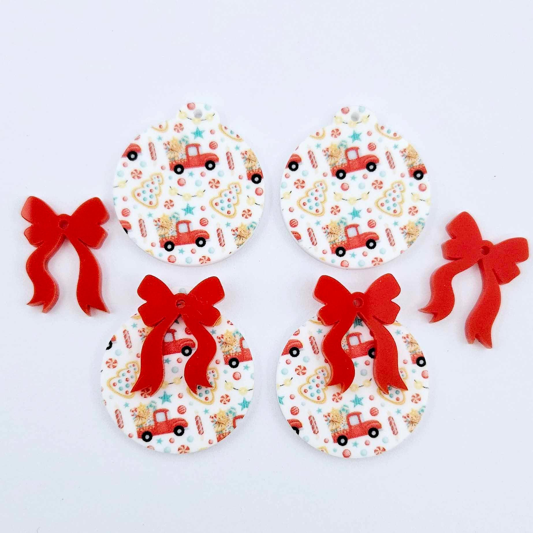 Two pairs of Vintage Truck UV printed bauble dangle blanks with included solid red bows laying flat