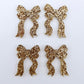 Two pairs of rose gold glitter bow dangle earring blanks laying flat