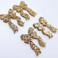 Two pairs of rose gold glitter bow dangle earring blanks laying flat