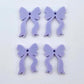 Two pairs of pastel purple acrylic bow dangle earring blanks laying flat