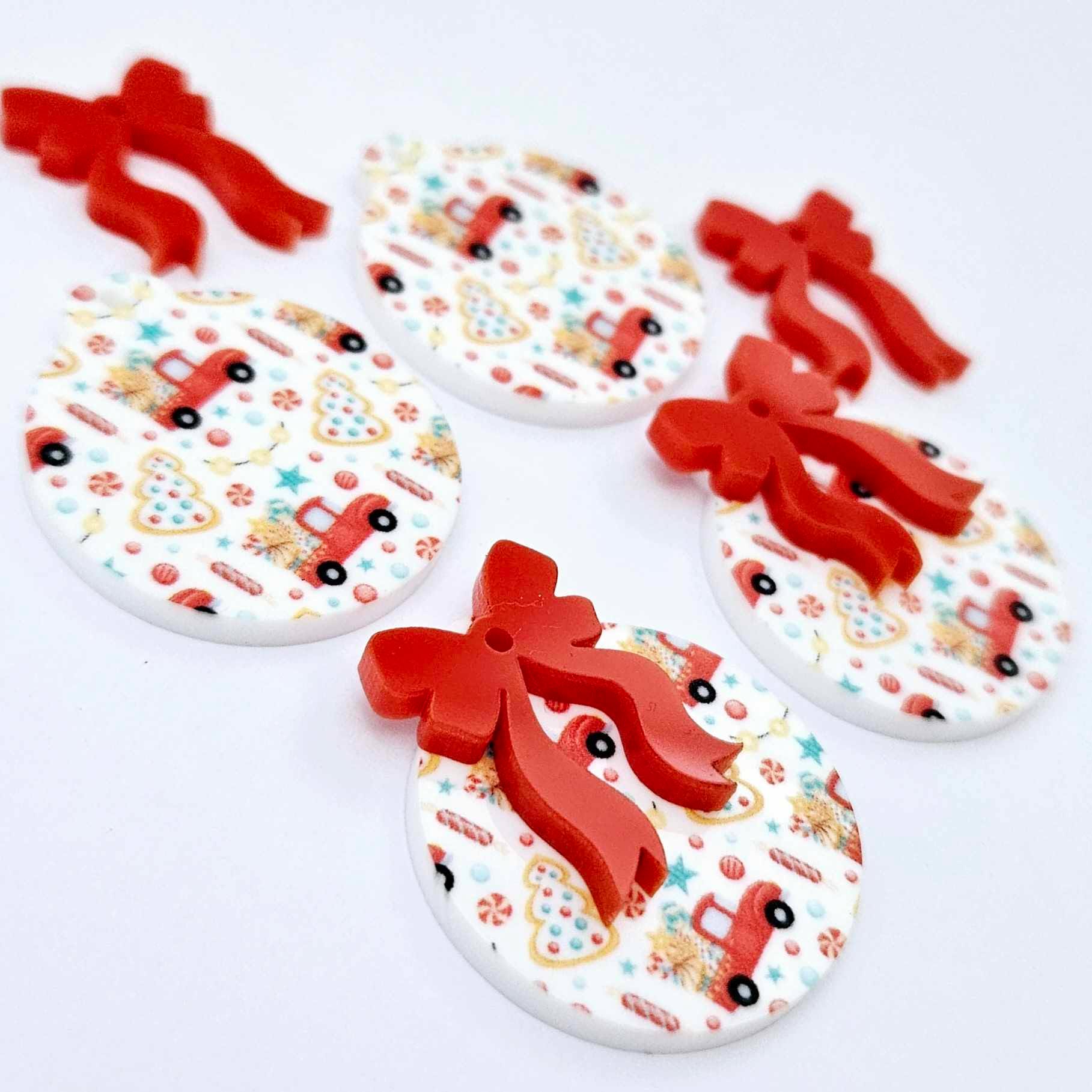 Two pairs of Vintage Truck UV printed bauble dangle blanks with included solid red bows laying flat
