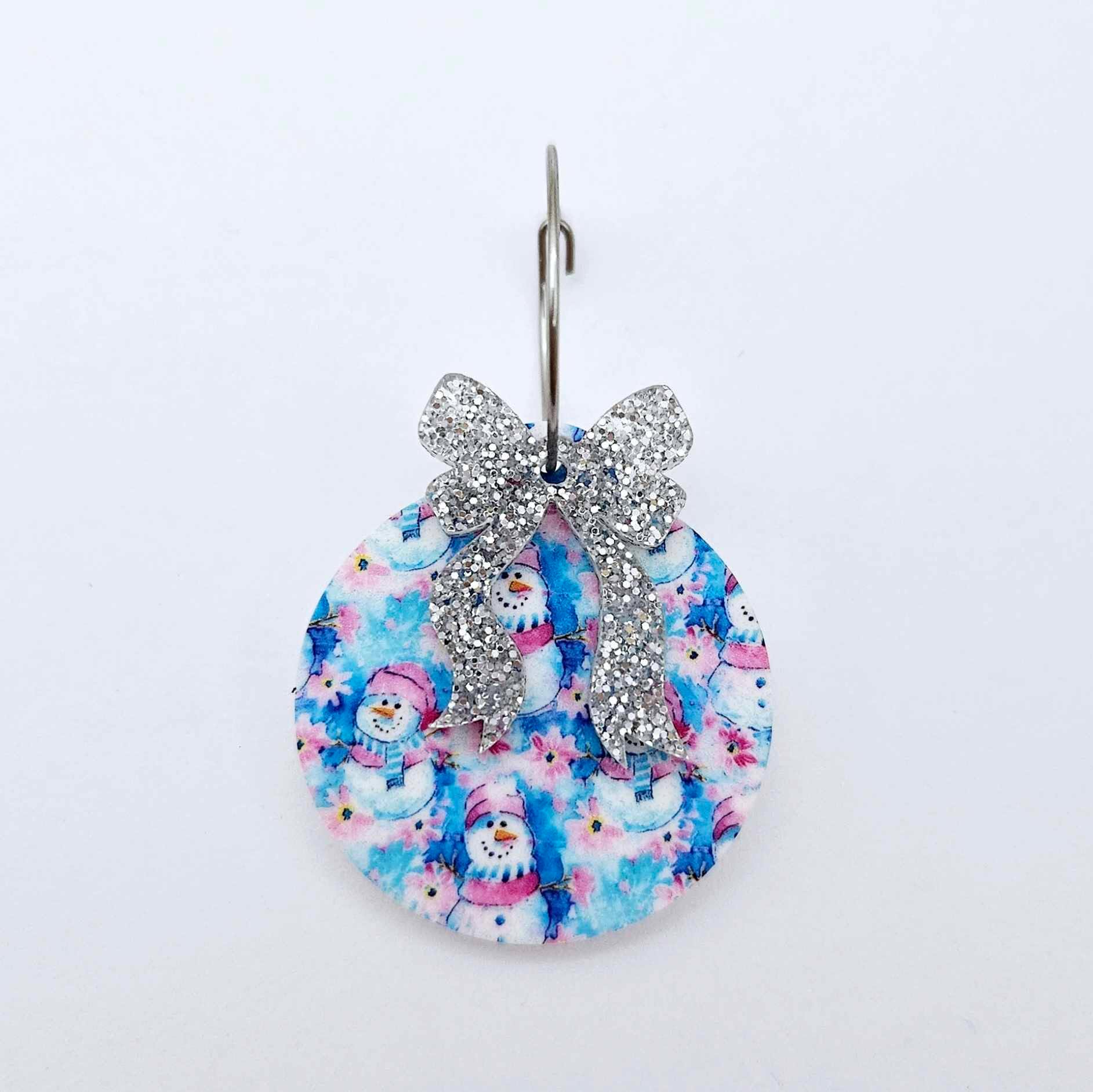One silver glitter acrylic bow shown paired with a UV printed bauble on a 20mm hoop