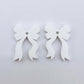 One pair of white acrylic bow dangle earring blanks laying flat