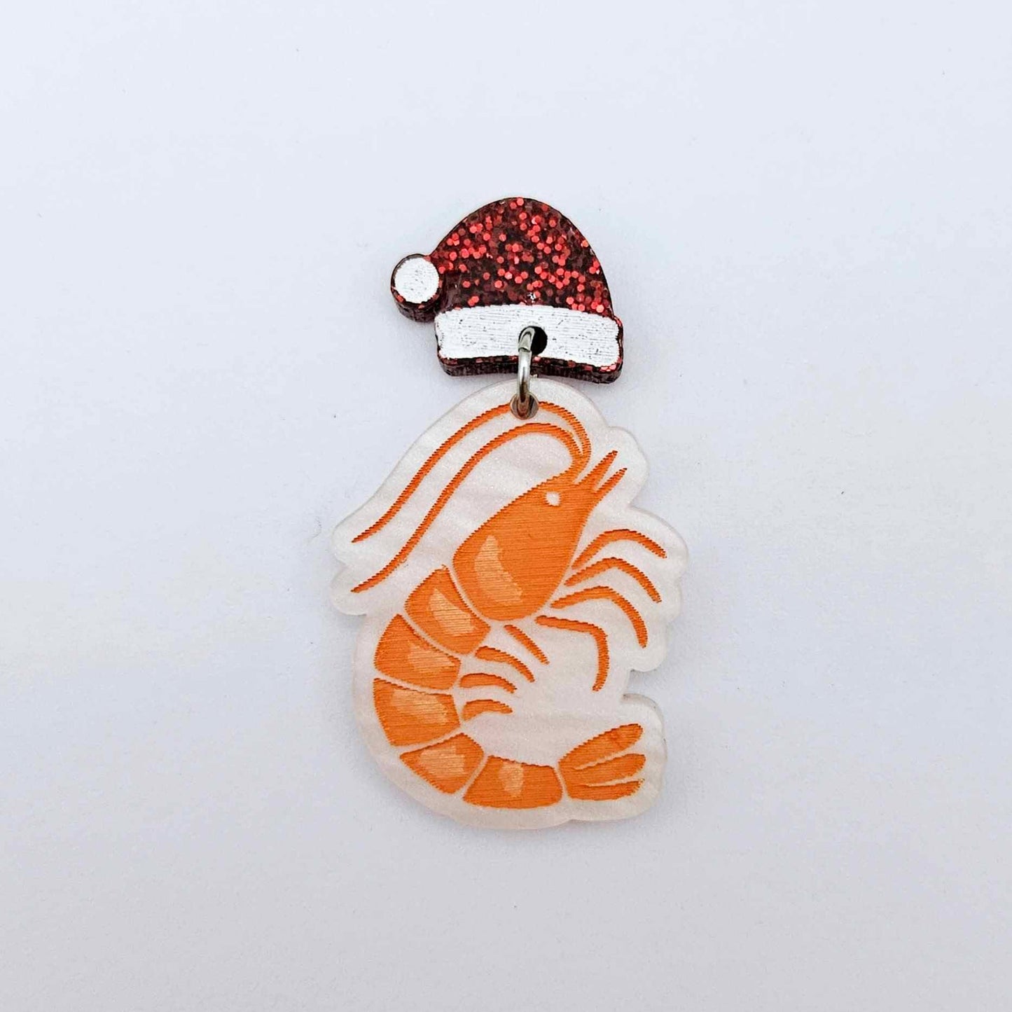 One white marble acrylic prawn dangle earring blank assembled with a Santa Hat Topper, shown as a festive Australian Christmas earring
