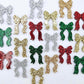 A selection of the traditional glitter acrylic bow dangle earring blanks in red, green, gold, silver and rose gold glitter laying flat