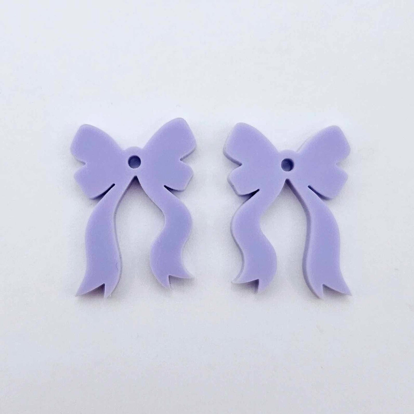  One pair of pastel purple acrylic bow dangle earring blanks laying flat
