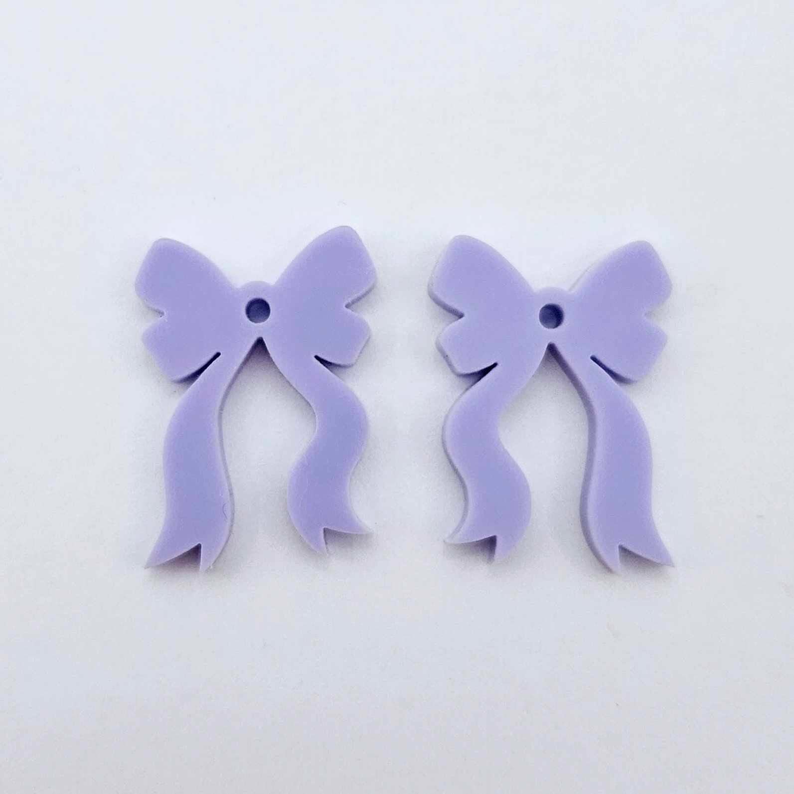  One pair of pastel purple acrylic bow dangle earring blanks laying flat