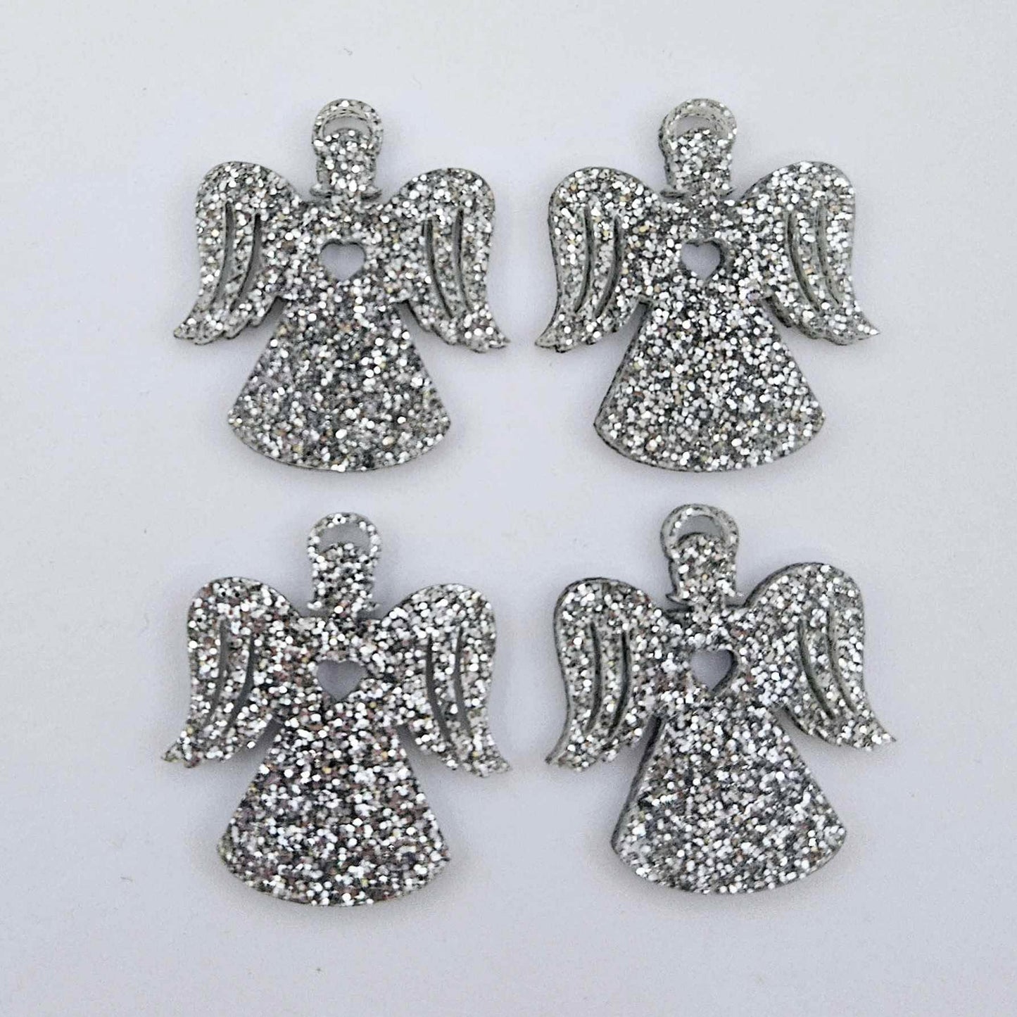 Two pairs of 32mm silver glitter acrylic angel dangle earring blanks laying flat on a white background