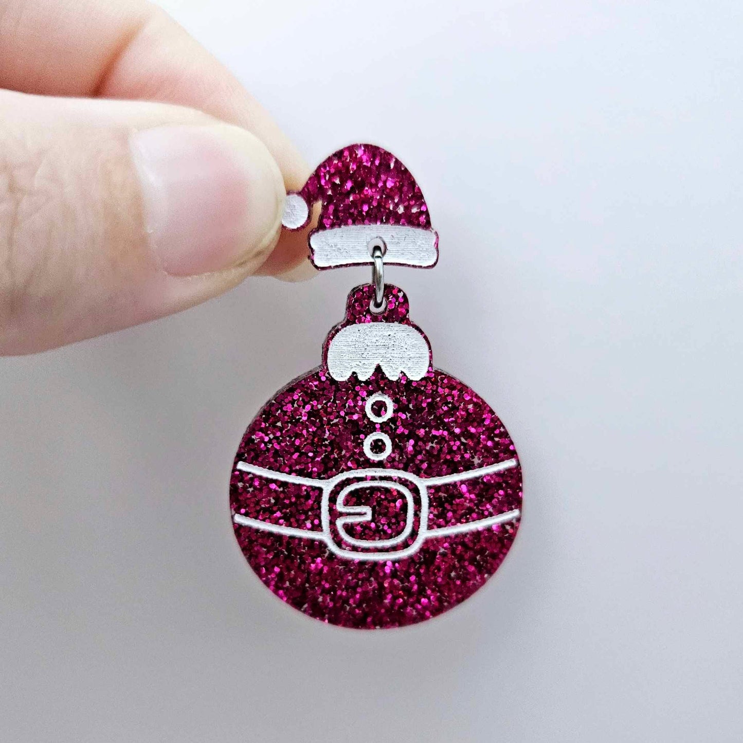 One hot pink glitter acrylic Santa hat topper attached to a Christmas Santa Bauble dangle, shown as a finished festive earring design
