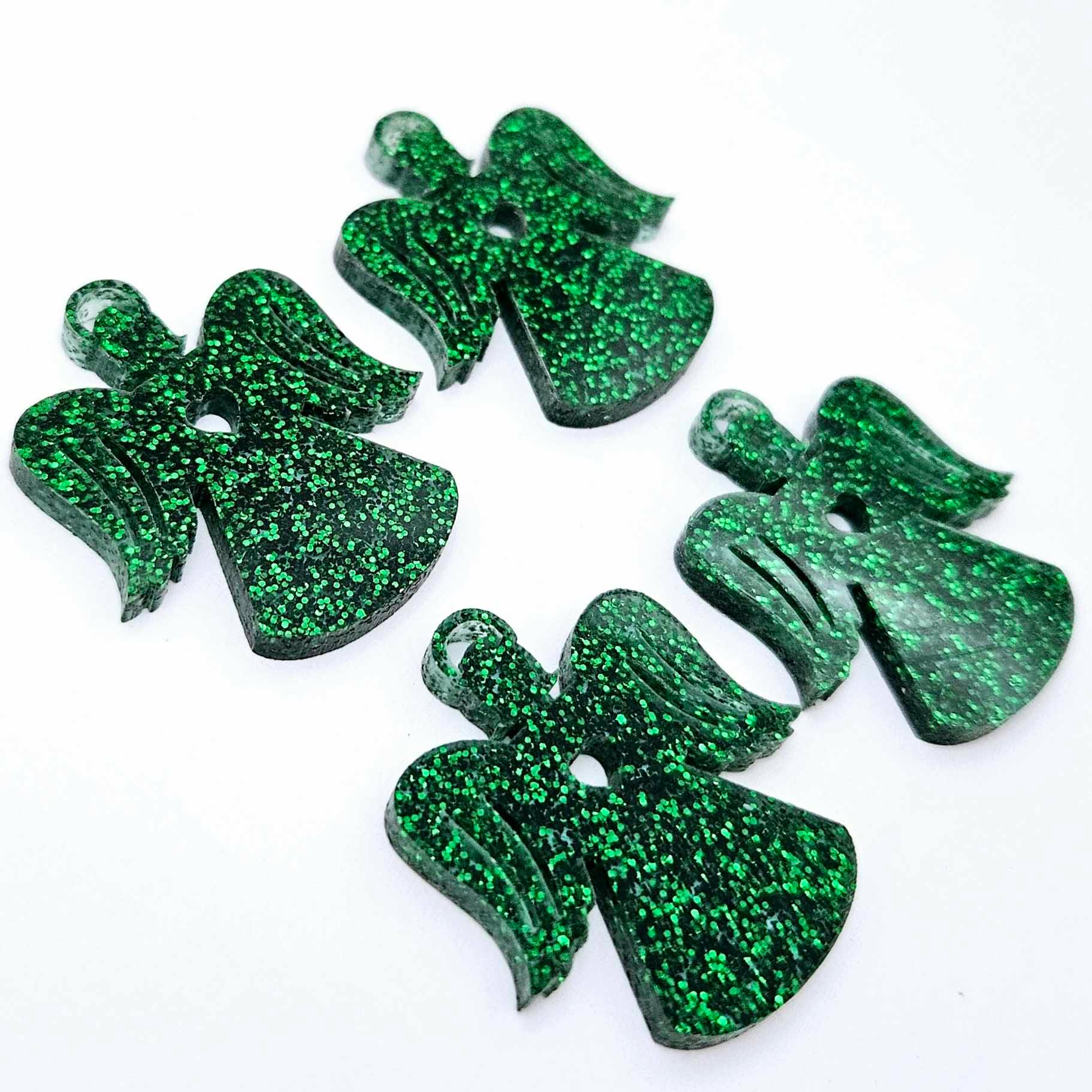 Two pairs of 32mm green glitter acrylic angel dangle earring blanks laying flat on a white background