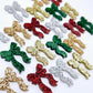 A selection of the traditional glitter acrylic bow dangle earring blanks in red, green, gold, silver and rose gold glitter laying flat