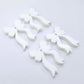 Two pairs of white acrylic bow dangle  earring blanks laying flat