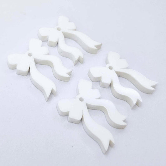 Two pairs of white acrylic bow dangle  earring blanks laying flat