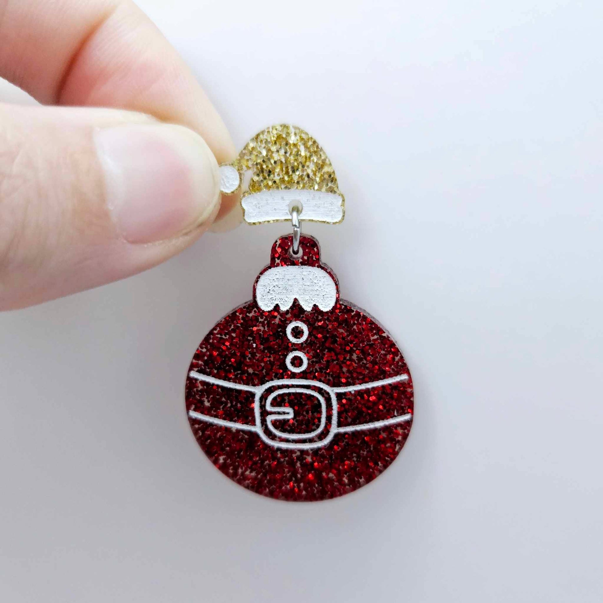 One gold glitter acrylic Santa hat topper attached to a Christmas Santa Bauble dangle, shown as a finished festive earring design