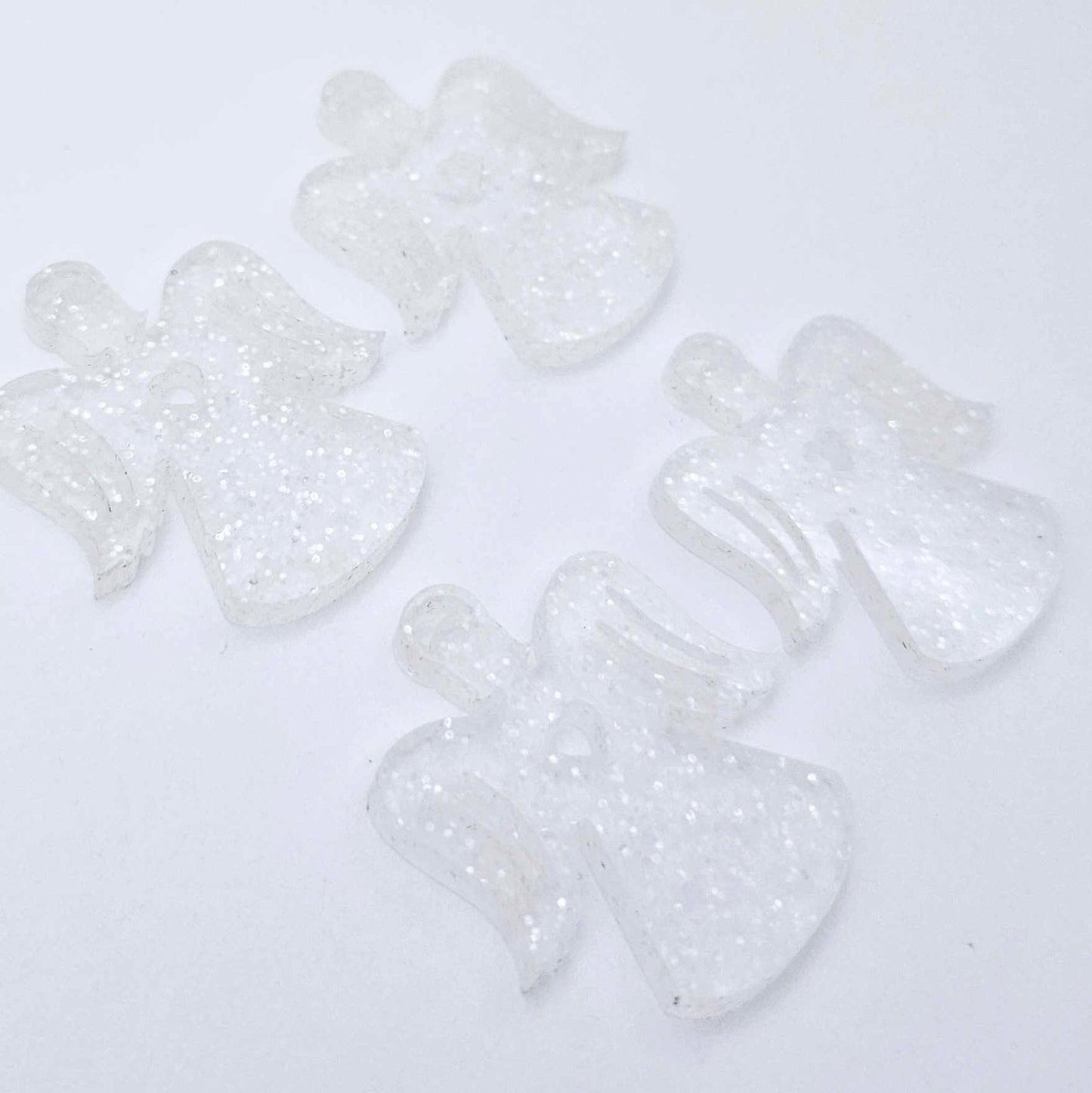 Two pairs of 32mm fairy dust glitter acrylic angel dangle earring blanks laying flat on a white background
