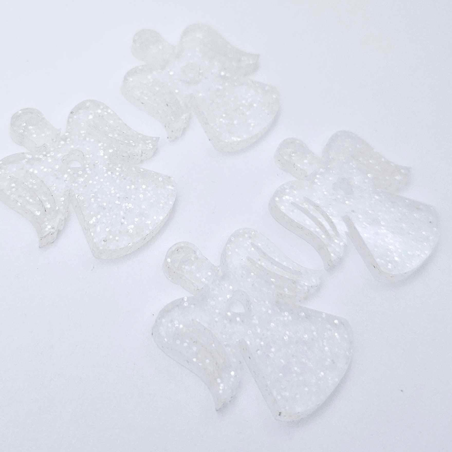 Two pairs of 32mm fairy dust glitter acrylic angel dangle earring blanks laying flat on a white background