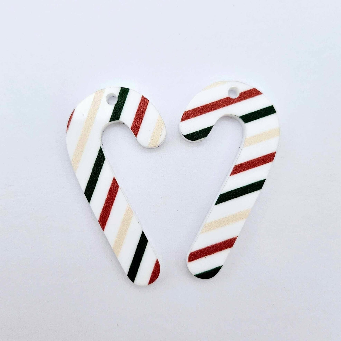 One pair of Stripy Christmas UV printed acrylic candy cane dangle earring blanks laying flat 