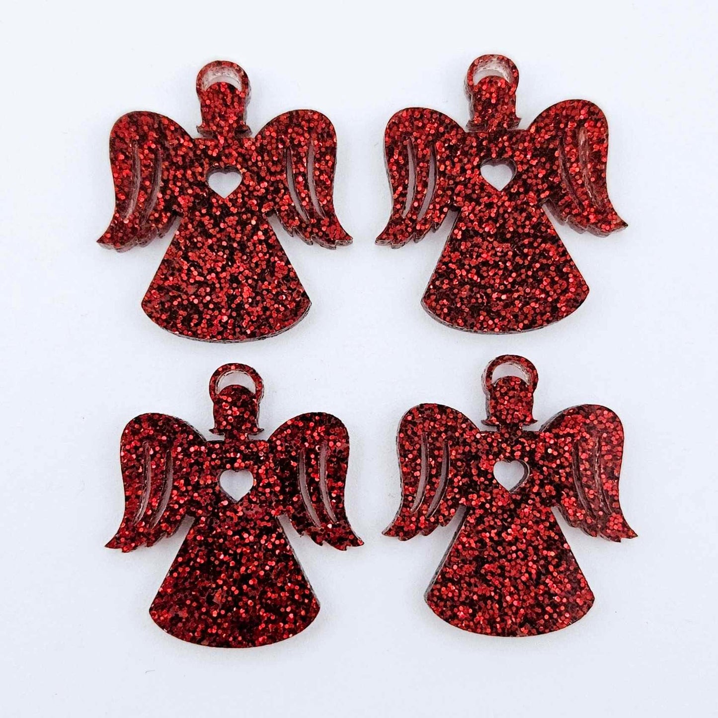 Two pairs of 32mm red glitter acrylic angel dangle earring blanks laying flat on a white background