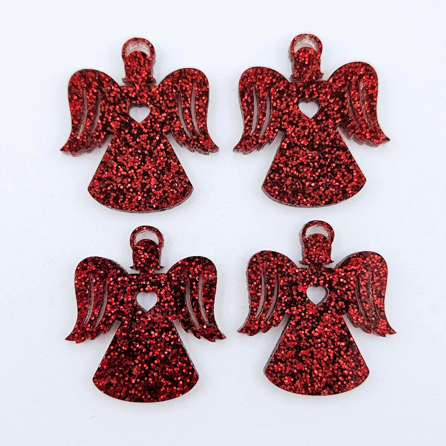 Two pairs of 32mm red glitter acrylic angel dangle earring blanks laying flat on a white background