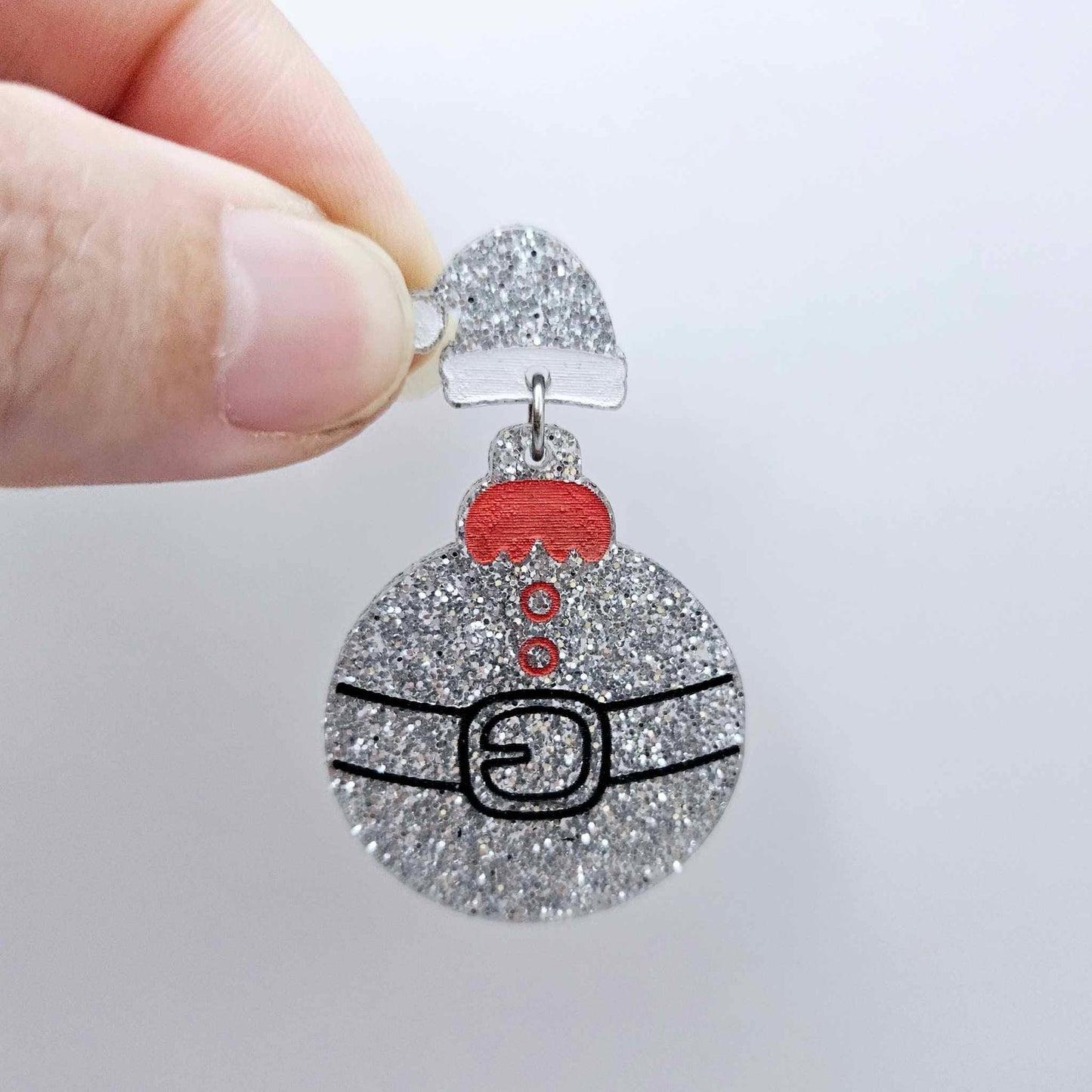 One silver glitter acrylic Santa hat topper attached to a Christmas Santa Bauble dangle, shown as a finished festive earring design