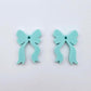 One pair of pastel aqua acrylic bow dangle earring blanks laying flat
