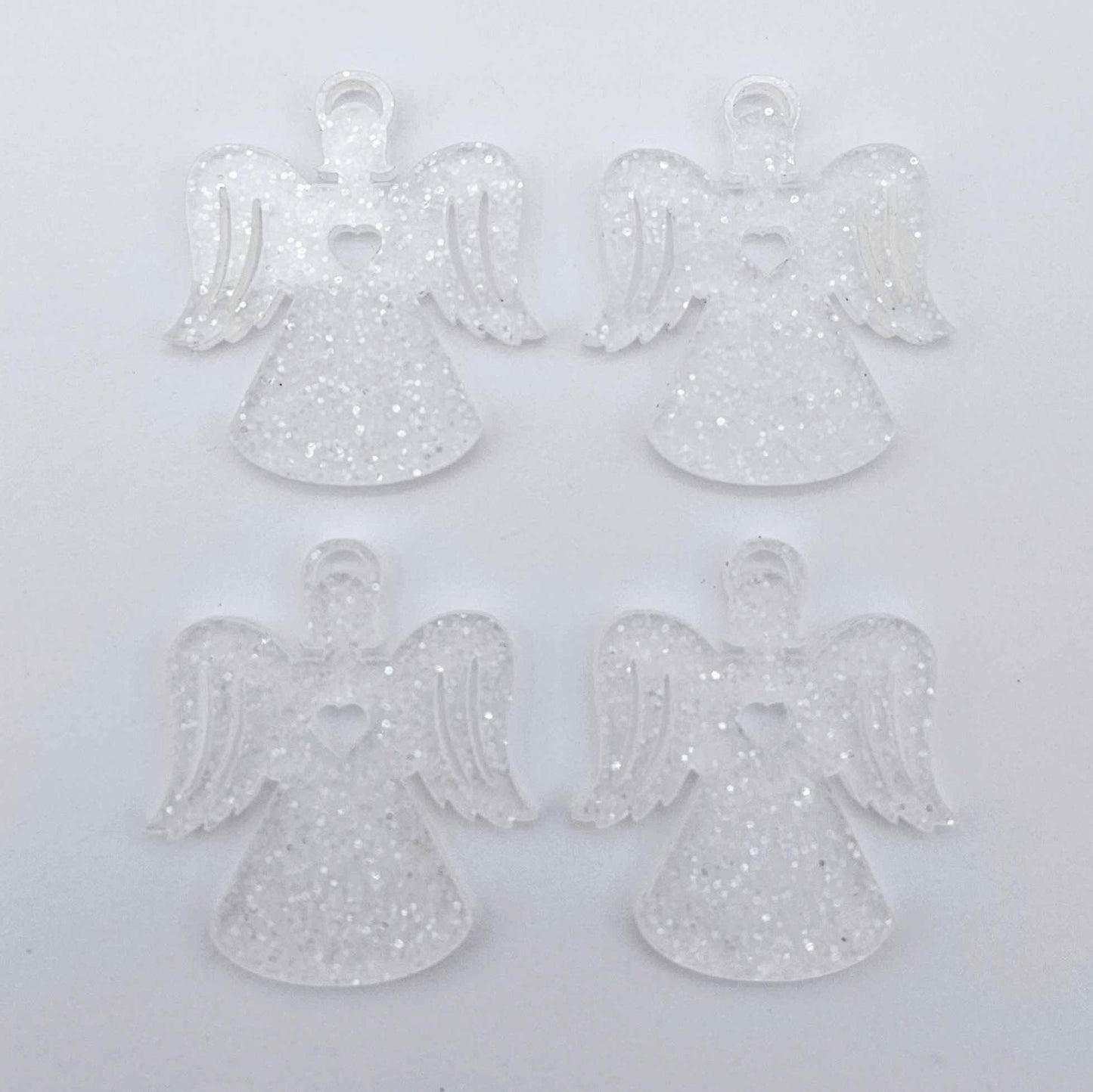Two pairs of 32mm fairy dust glitter acrylic angel dangle earring blanks laying flat on a white background