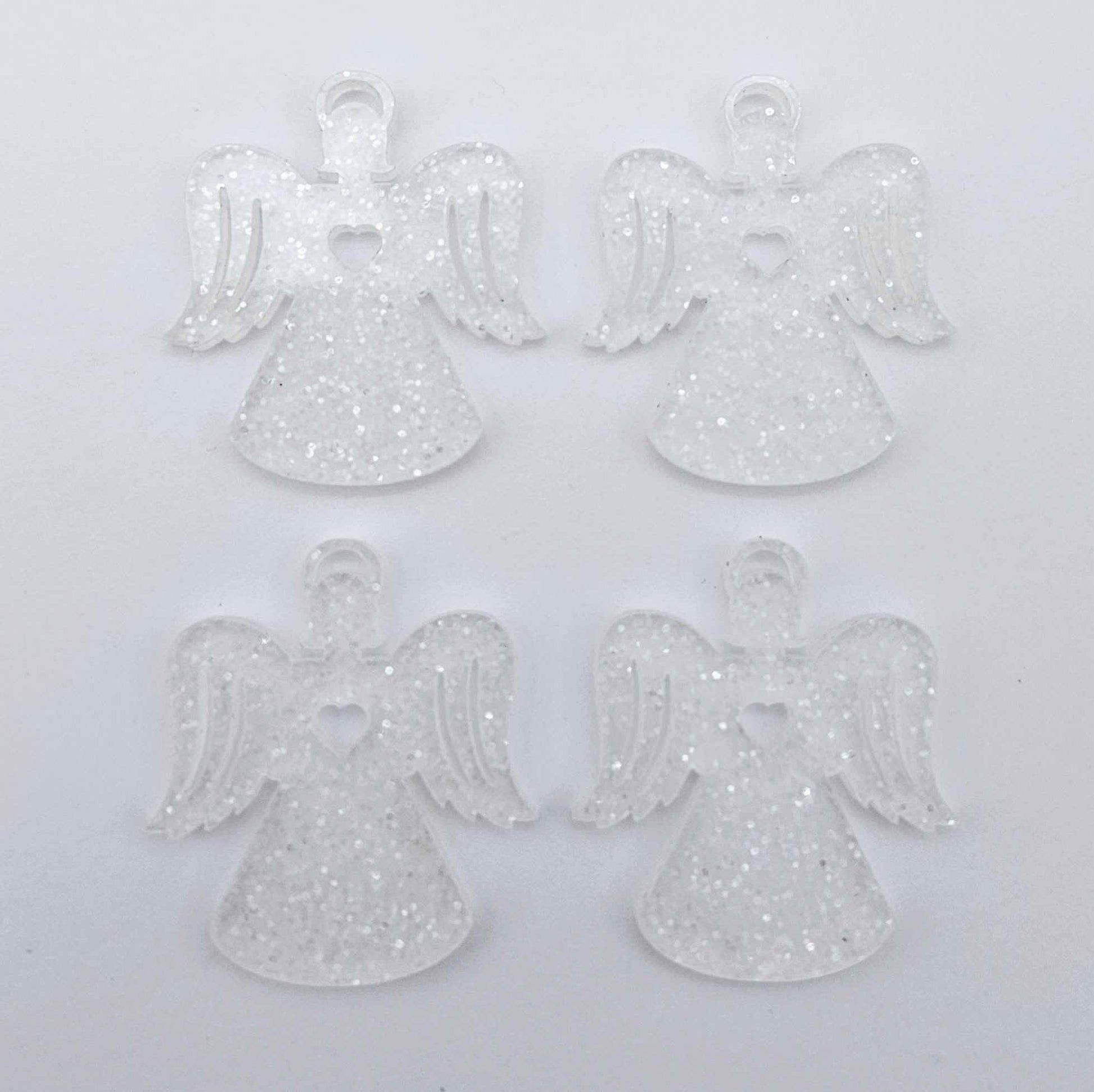 Two pairs of 32mm fairy dust glitter acrylic angel dangle earring blanks laying flat on a white background