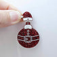 One red glitter Santa hat topper attached to a Christmas Santa bauble dangle, shown as a finished festive earring design