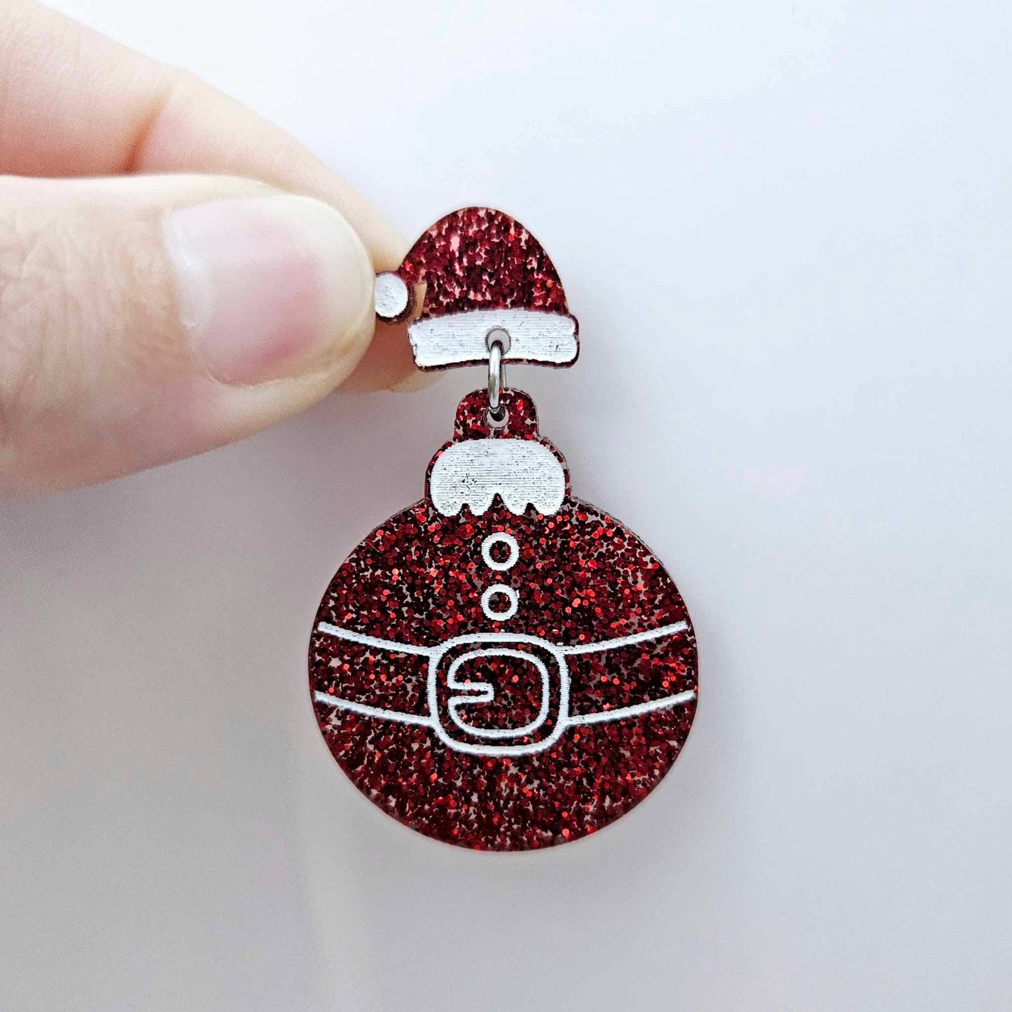 One red glitter Santa hat topper attached to a Christmas Santa bauble dangle, shown as a finished festive earring design