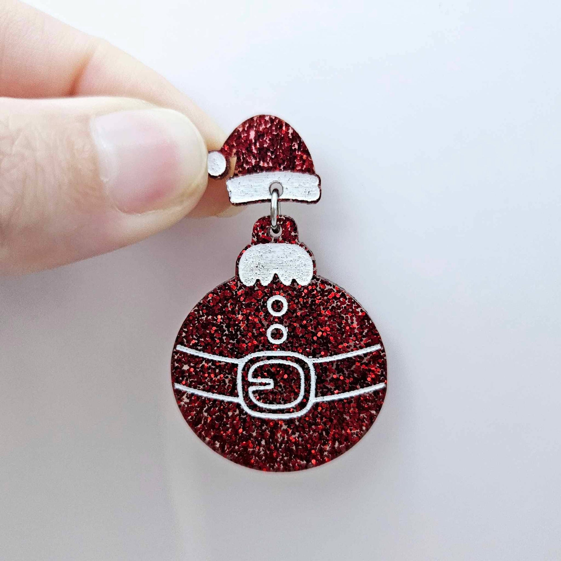 One red glitter Santa hat topper attached to a Christmas Santa bauble dangle, shown as a finished festive earring design