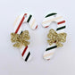 One pair of Stripy Christmas UV printed acrylic candy cane dangle earring blanks laying flat with gold glitter bows attached