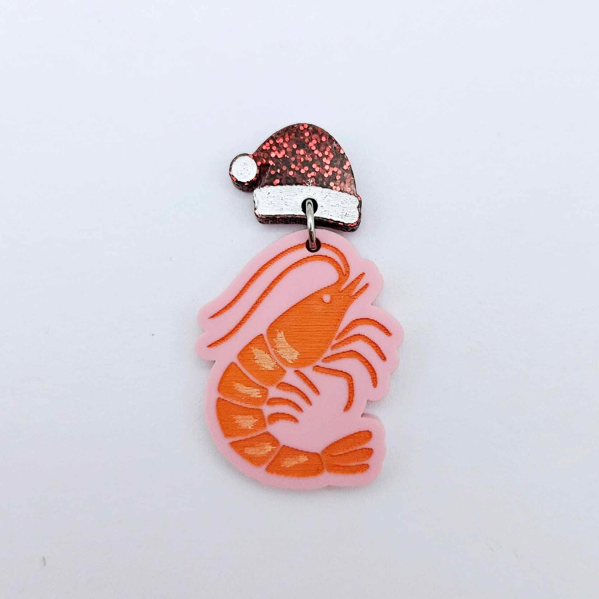 One pastel pink acrylic prawn dangle earring blank assembled with a Santa Hat Topper, shown as a festive Australian Christmas earring