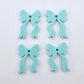 Two pairs of pastel aqua acrylic bow dangle earring blanks laying flat