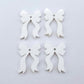Two pairs of white acrylic bow dangle  earring blanks laying flat