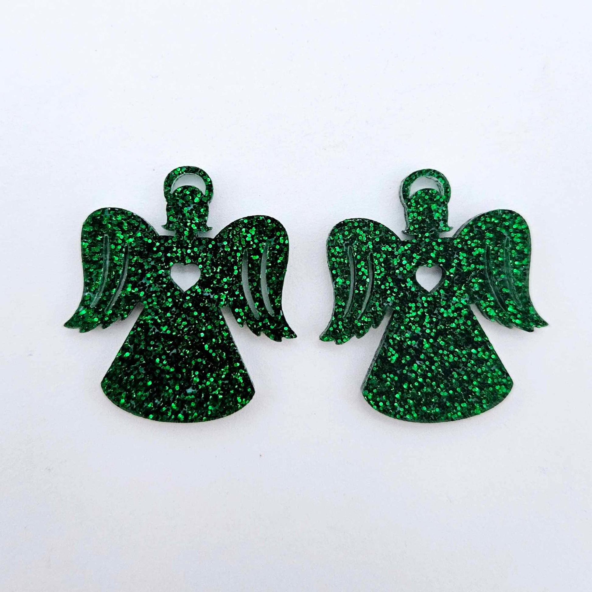 One pair of 32mm green glitter acrylic angel dangle earring blanks laying flat on a white background