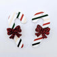 One pair of Stripy Christmas UV printed acrylic candy cane dangle earring blanks laying flat with red glitter bows attached