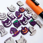 A mixed selection of holographic purple glitter acrylic Halloween stud earring blanks featuring Spooky Cats, Witch’s Cauldrons, Jack-O’-Lanterns, Spooky Face Masks and Witch’s Hats laying flat