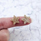 One pair of 14mm rose gold glitter acrylic star stud earring blanks shown on a finger for size reference