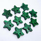 Five pairs of 14mm green glitter acrylic star earring toppers laying flat