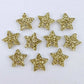 Five pairs of 14mm gold glitter acrylic star earring toppers laying flat