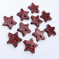 Five pairs of 14mm red glitter acrylic star earring toppers laying flat