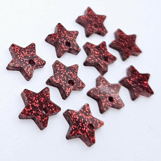 Five pairs of 14mm red glitter acrylic star earring toppers laying flat