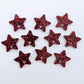 Five pairs of 14mm red glitter acrylic star earring toppers laying flat